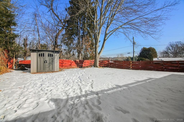 yard covered in snow featuring a storage shed