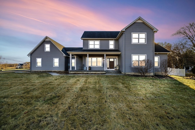 view of front of home featuring covered porch and a lawn