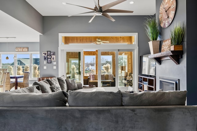 living room featuring ceiling fan and a healthy amount of sunlight