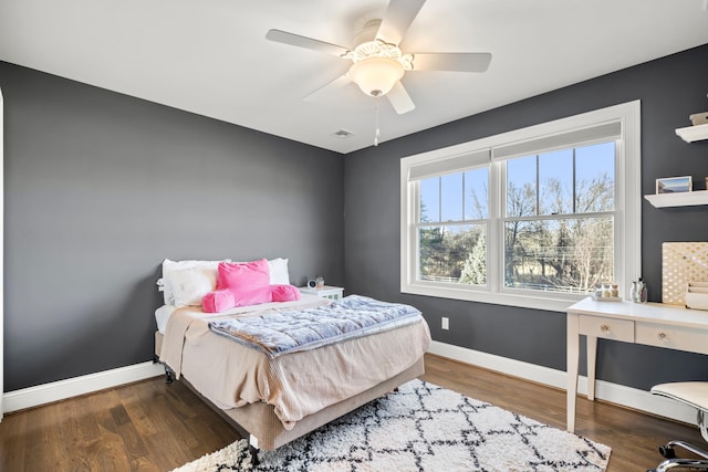 bedroom with dark hardwood / wood-style flooring and ceiling fan