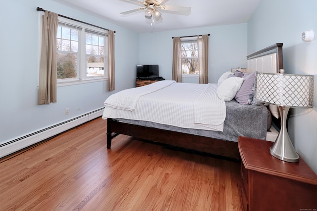 bedroom with ceiling fan, light hardwood / wood-style flooring, and a baseboard radiator