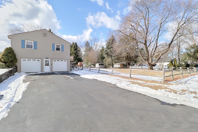 snow covered property with a garage