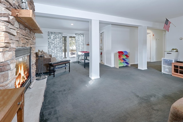 basement featuring dark colored carpet and a fireplace