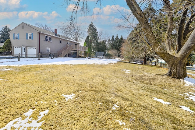 snowy yard featuring a garage