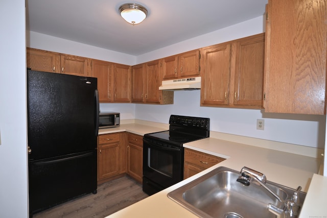 kitchen with sink, black appliances, and dark hardwood / wood-style floors