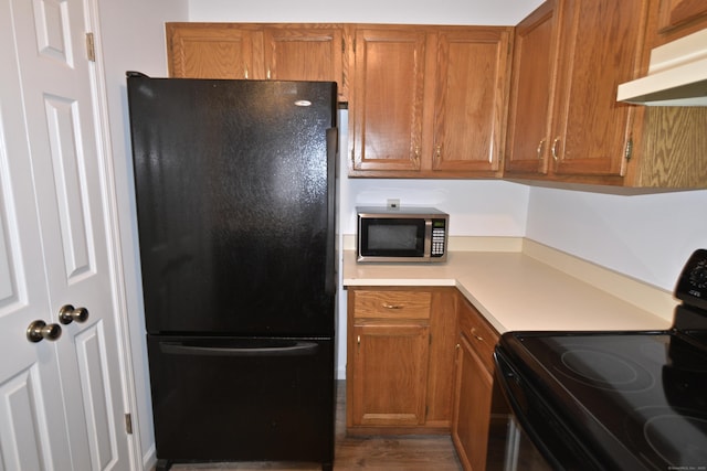 kitchen featuring wood-type flooring and black appliances