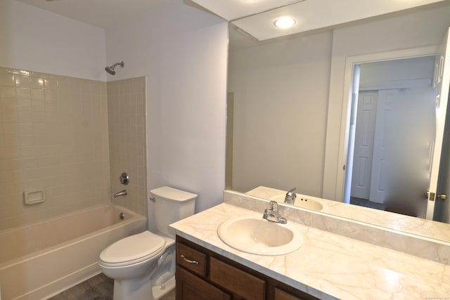 full bathroom featuring vanity, hardwood / wood-style flooring, toilet, and washtub / shower combination