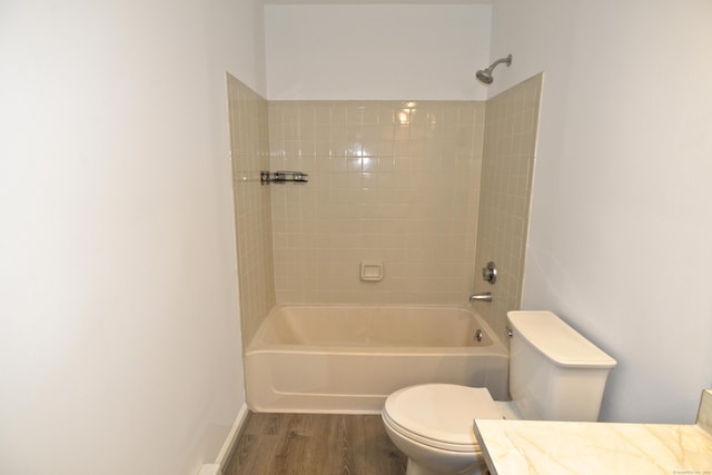 full bathroom featuring hardwood / wood-style flooring, tiled shower / bath, vanity, and toilet