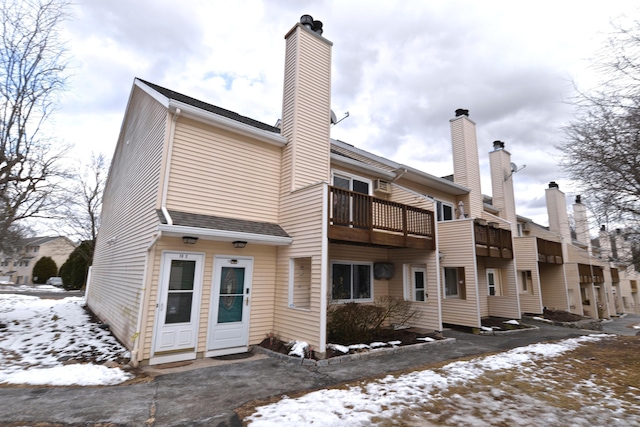 snow covered property with a balcony