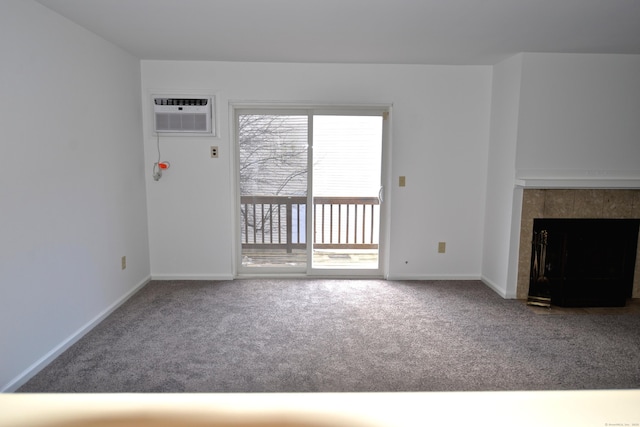 unfurnished living room with a wall mounted air conditioner, a tile fireplace, and carpet