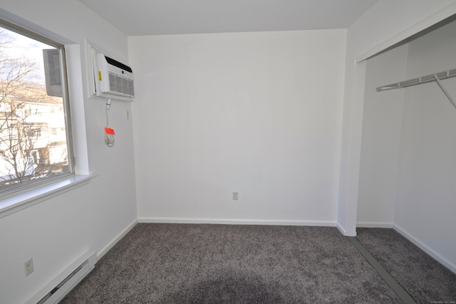 unfurnished bedroom featuring a baseboard radiator, an AC wall unit, a closet, and dark colored carpet