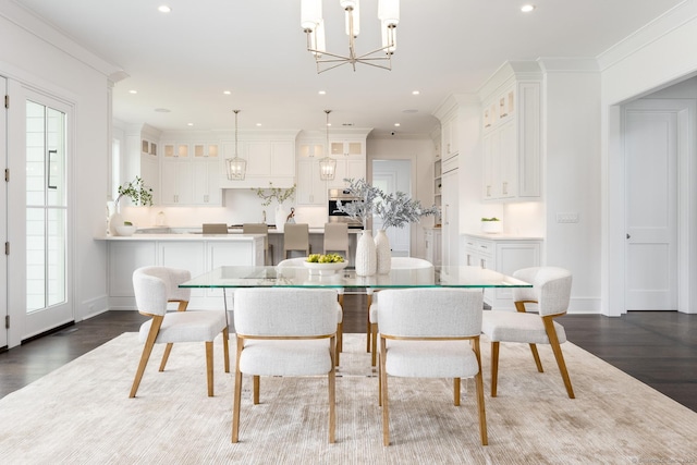 dining area featuring crown molding, dark wood-type flooring, and an inviting chandelier