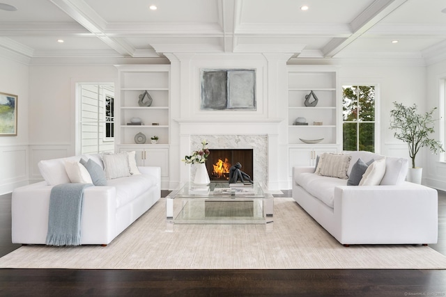 living room with coffered ceiling, a high end fireplace, beam ceiling, and built in shelves