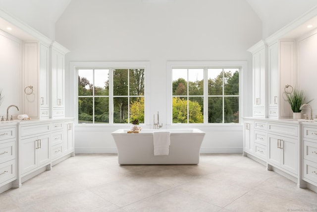 bathroom featuring vanity, a bath, tile patterned floors, and high vaulted ceiling