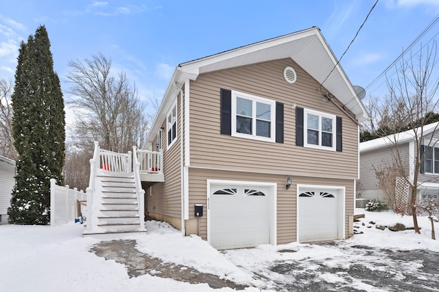 snow covered property with a garage