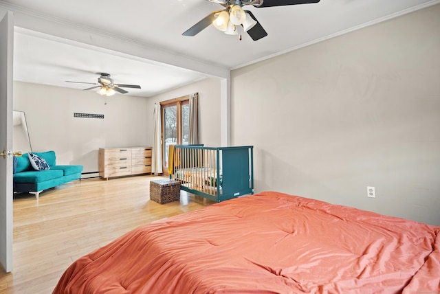 bedroom with hardwood / wood-style floors, a baseboard radiator, and ceiling fan