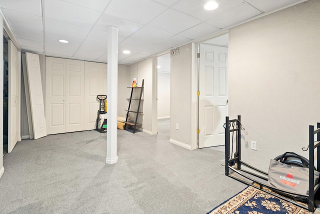 exercise area with a paneled ceiling and light colored carpet