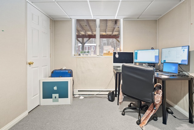 carpeted office space featuring a baseboard radiator and a drop ceiling