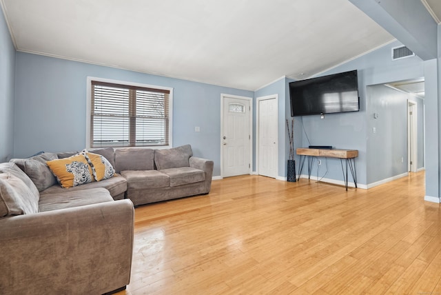 living room with ornamental molding, lofted ceiling, and light hardwood / wood-style flooring