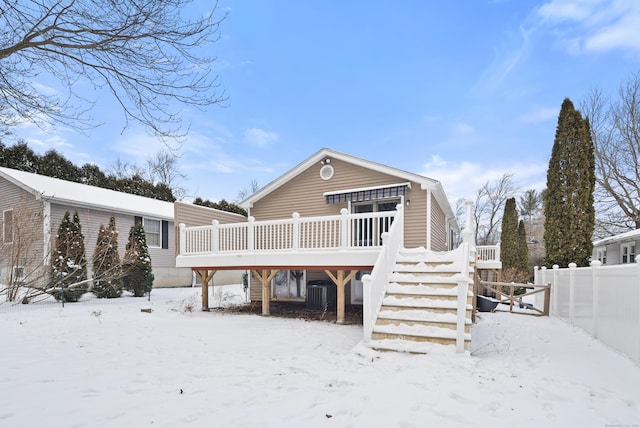 snow covered rear of property with a deck