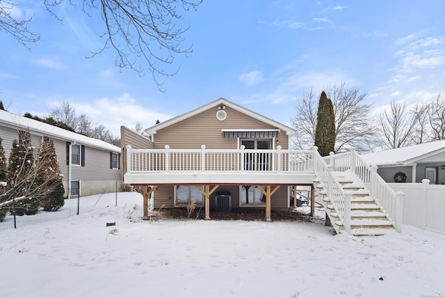 snow covered rear of property featuring a deck