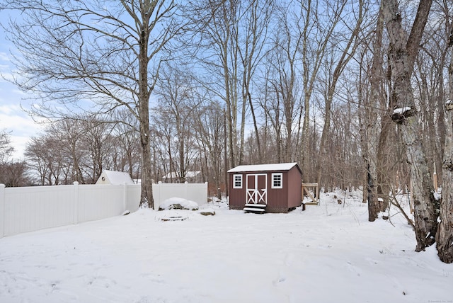 yard covered in snow featuring a shed