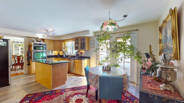 4 Alpine Dr, South Windsor, CT 06074 - kitchen featuring light wood-style floors, glass insert cabinets, a center island, appliances with stainless steel finishes, and dark countertops