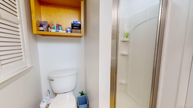 bathroom with an enclosed shower and toilet