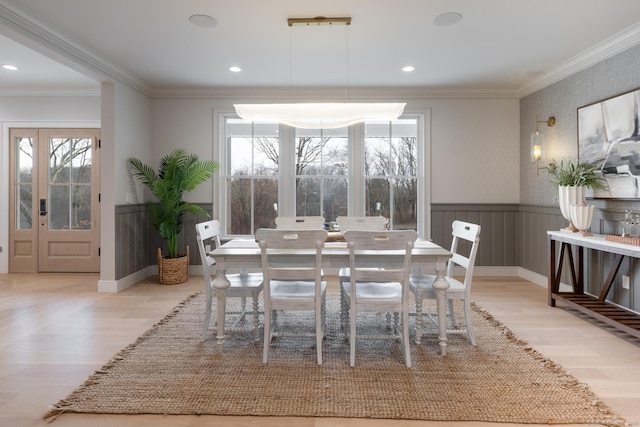 dining area with crown molding and light hardwood / wood-style flooring