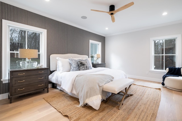 bedroom with crown molding, ceiling fan, and light hardwood / wood-style flooring