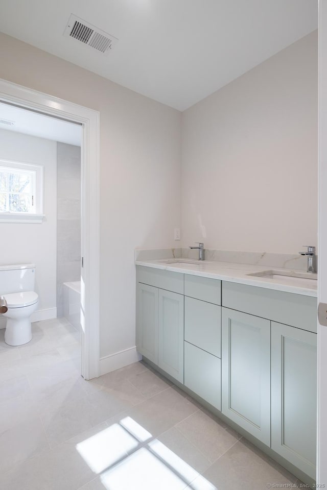 bathroom with vanity, tile patterned flooring, and toilet