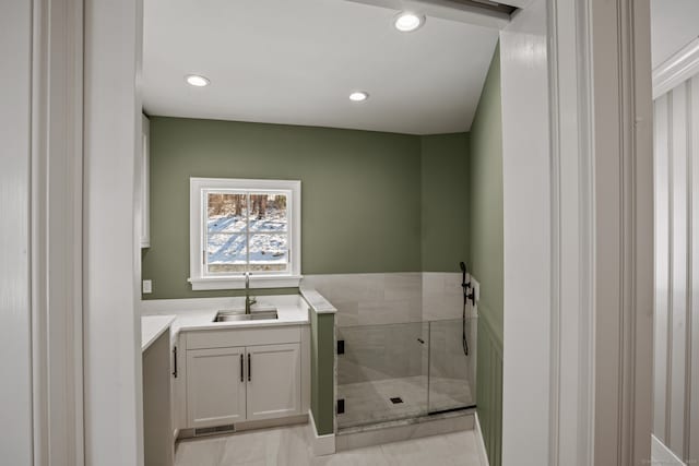 bathroom featuring vanity and a shower with door