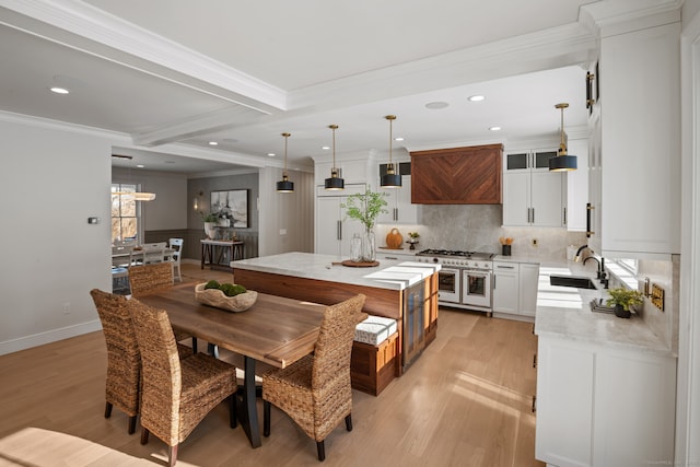 kitchen featuring decorative light fixtures, premium range hood, decorative backsplash, and a kitchen island