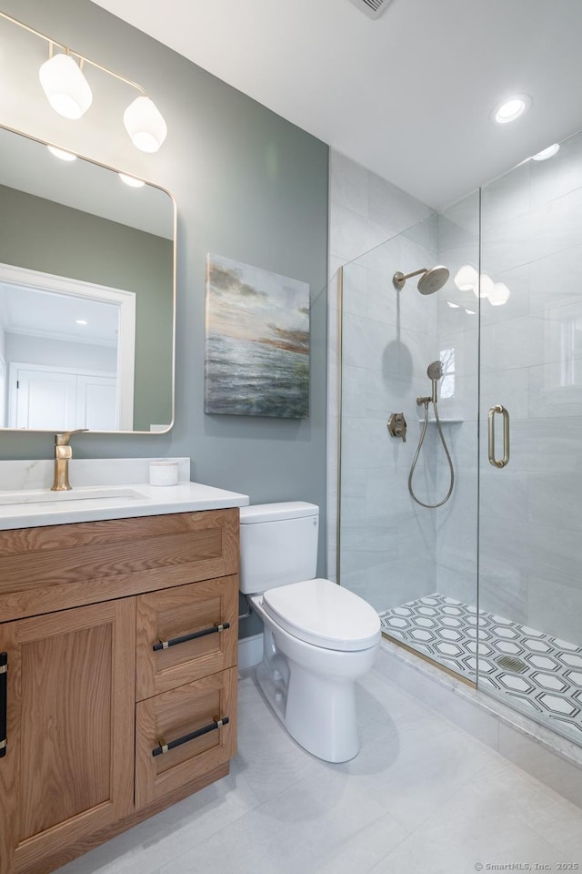 bathroom with vanity, a shower with door, and toilet