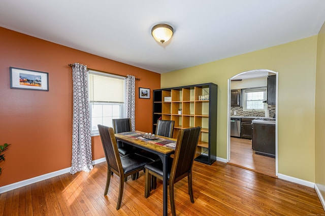 dining space with sink and wood-type flooring