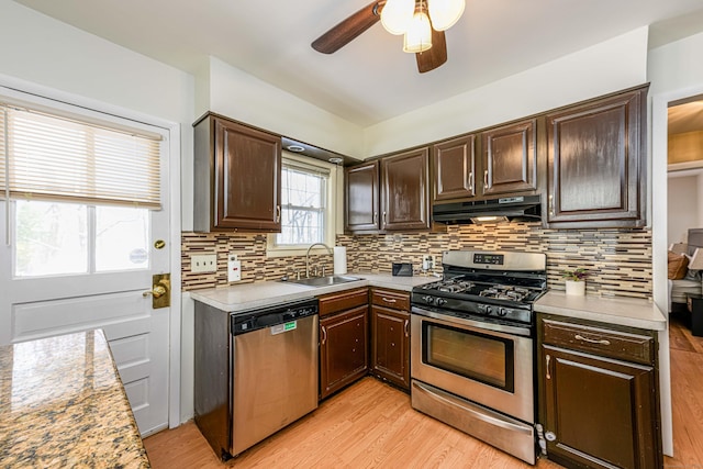 kitchen featuring dark brown cabinetry, sink, tasteful backsplash, stainless steel appliances, and light hardwood / wood-style floors