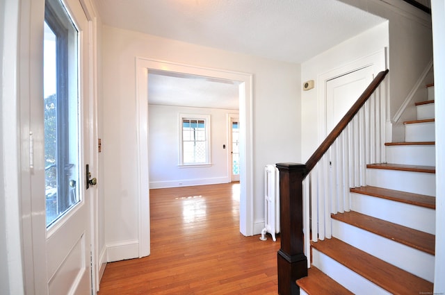 foyer entrance featuring radiator and light wood-type flooring