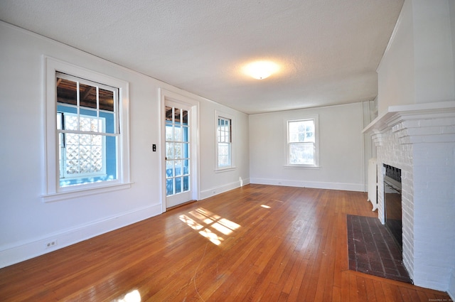 unfurnished living room featuring hardwood / wood-style floors, a textured ceiling, and a fireplace