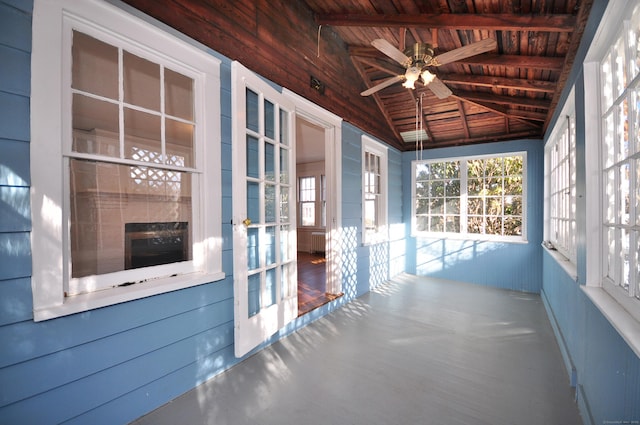 unfurnished sunroom with vaulted ceiling with beams, wood ceiling, and ceiling fan