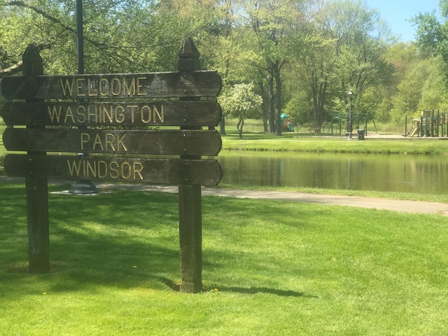 view of community with a water view and a lawn