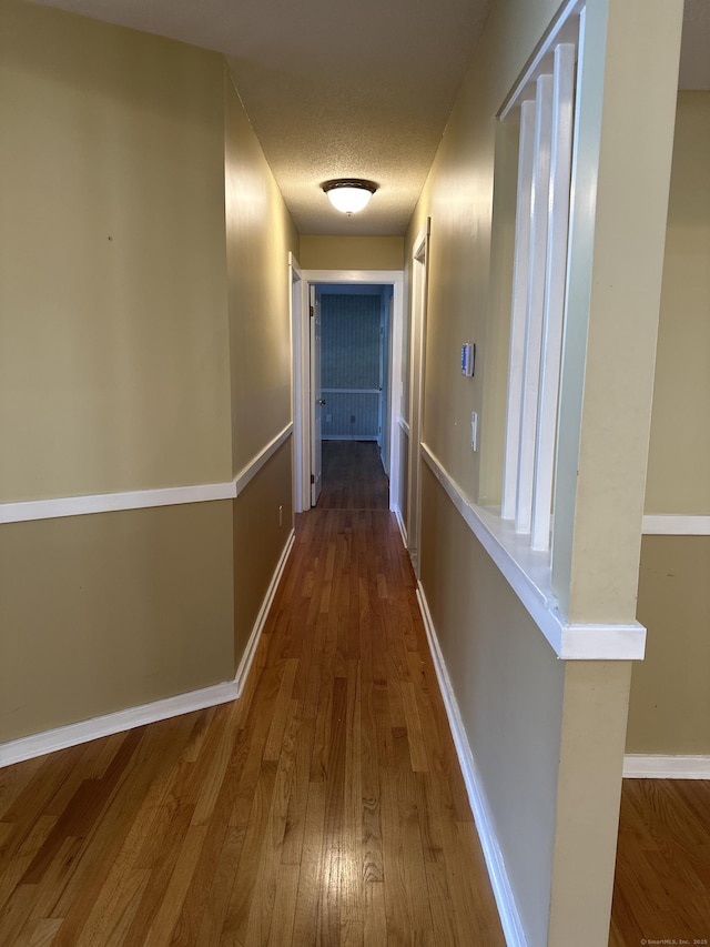 hall featuring hardwood / wood-style floors and a textured ceiling