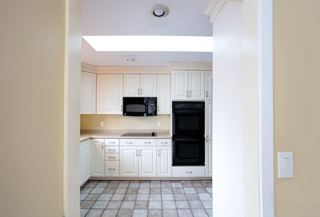 kitchen featuring white cabinets and black appliances