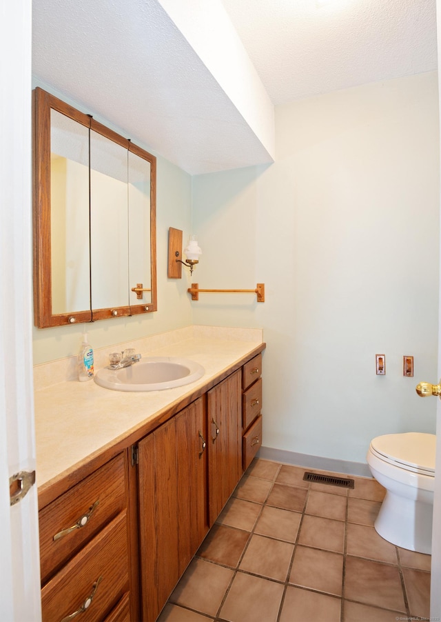 bathroom featuring vanity, tile patterned flooring, and toilet