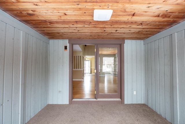 bonus room featuring wooden ceiling, wood walls, and carpet flooring