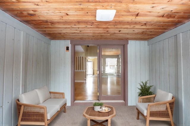 sitting room with wood ceiling and light colored carpet