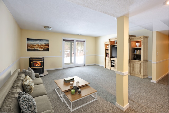 living room featuring carpet flooring, a textured ceiling, and a wood stove