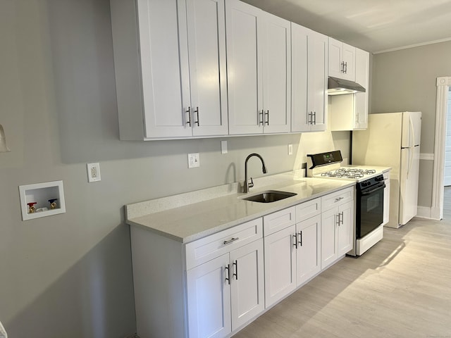 kitchen with range with gas stovetop, white cabinetry, sink, white fridge, and light stone countertops