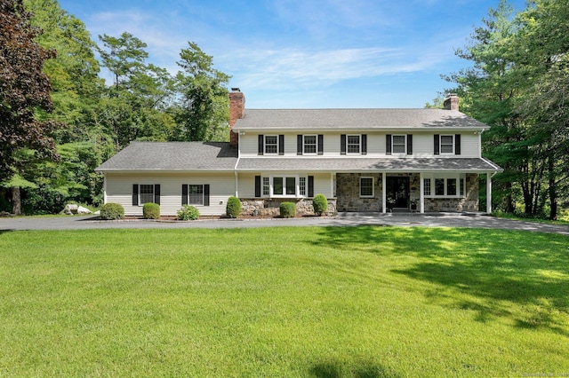 colonial-style house featuring a front lawn