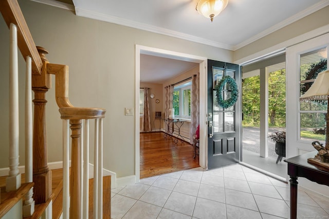 foyer entrance with light tile patterned floors, crown molding, and a healthy amount of sunlight