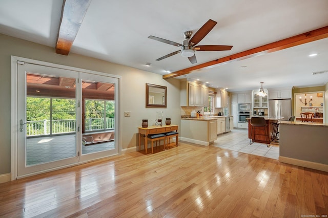 living room with sink, beam ceiling, ceiling fan, and light wood-type flooring